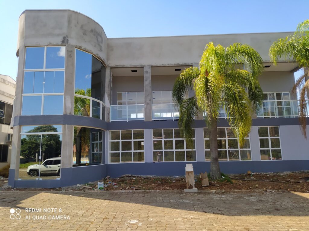 Fachada envidraçada de residência moderna com estrutura de alumínio e vidro temperado.