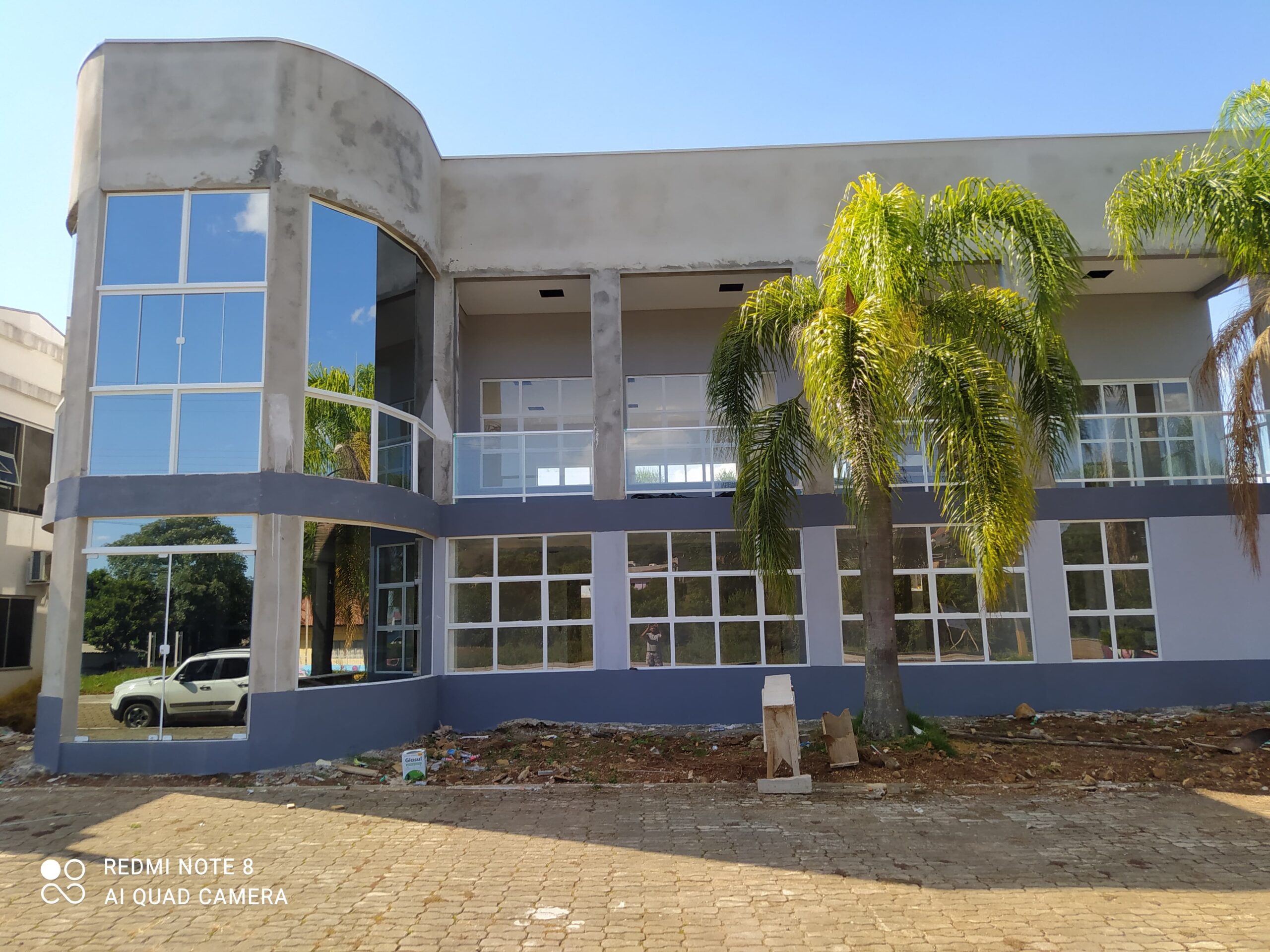 Fachada envidraçada de residência moderna com estrutura de alumínio e vidro temperado.