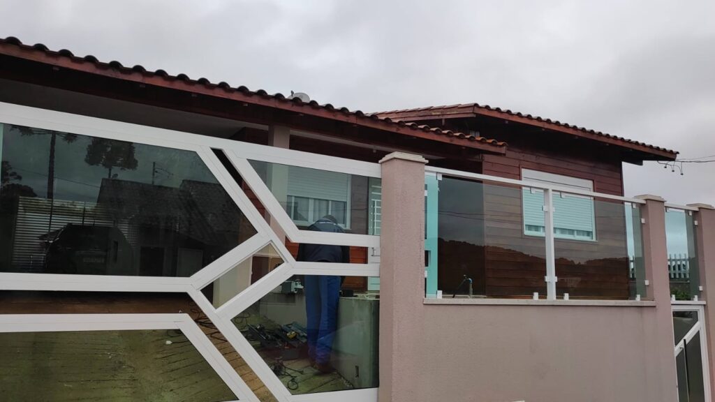 Portão de alumínio em tom branco com vidro, instalado pela Junior Glass.