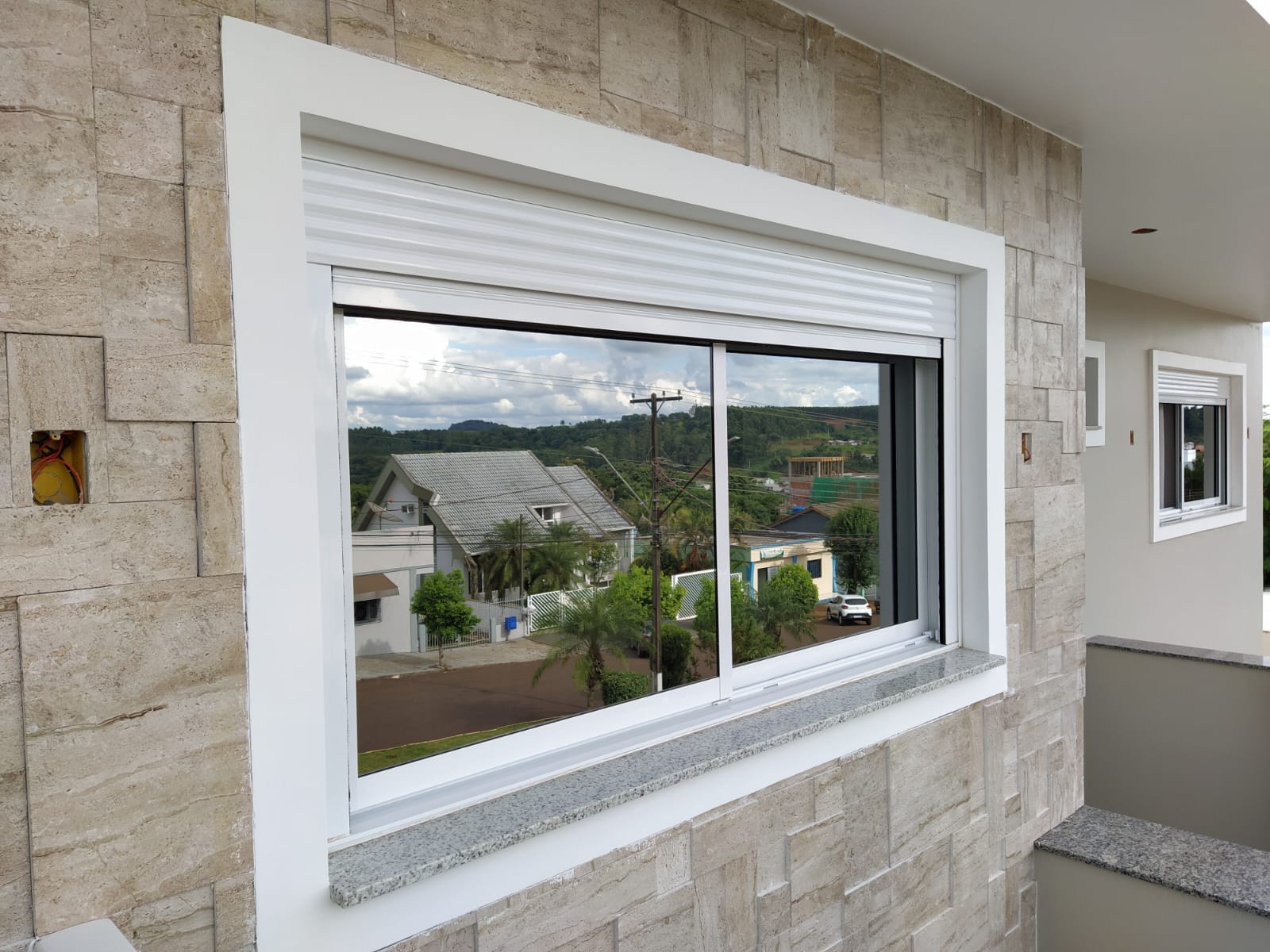 Janela com opção de persiana integrada e automação inteligente.